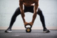 Muscular Man Lifting Kettle Ball