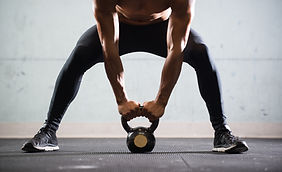 Muscular Man Lifting Kettle Ball