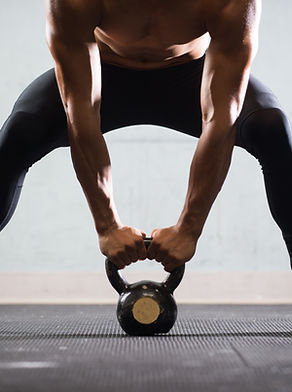 Muscular Man Lifting Kettle-Ball