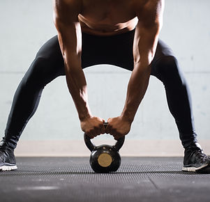 Muscular Man Lifting Kettle Ball