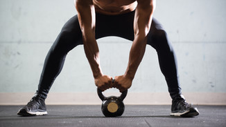 Muscular Man Lifting Kettle Ball