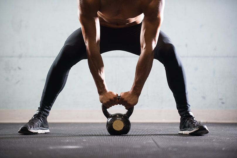Muscular Man Lifting Kettle Ball