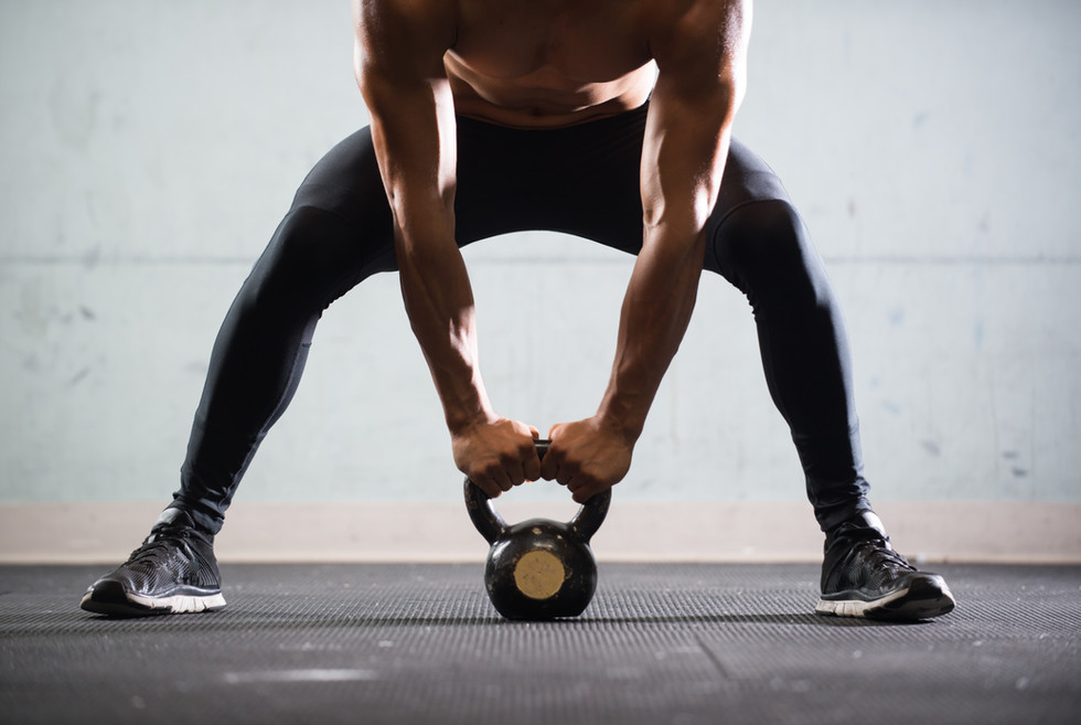 Muscular Man Lifting Kettle Ball