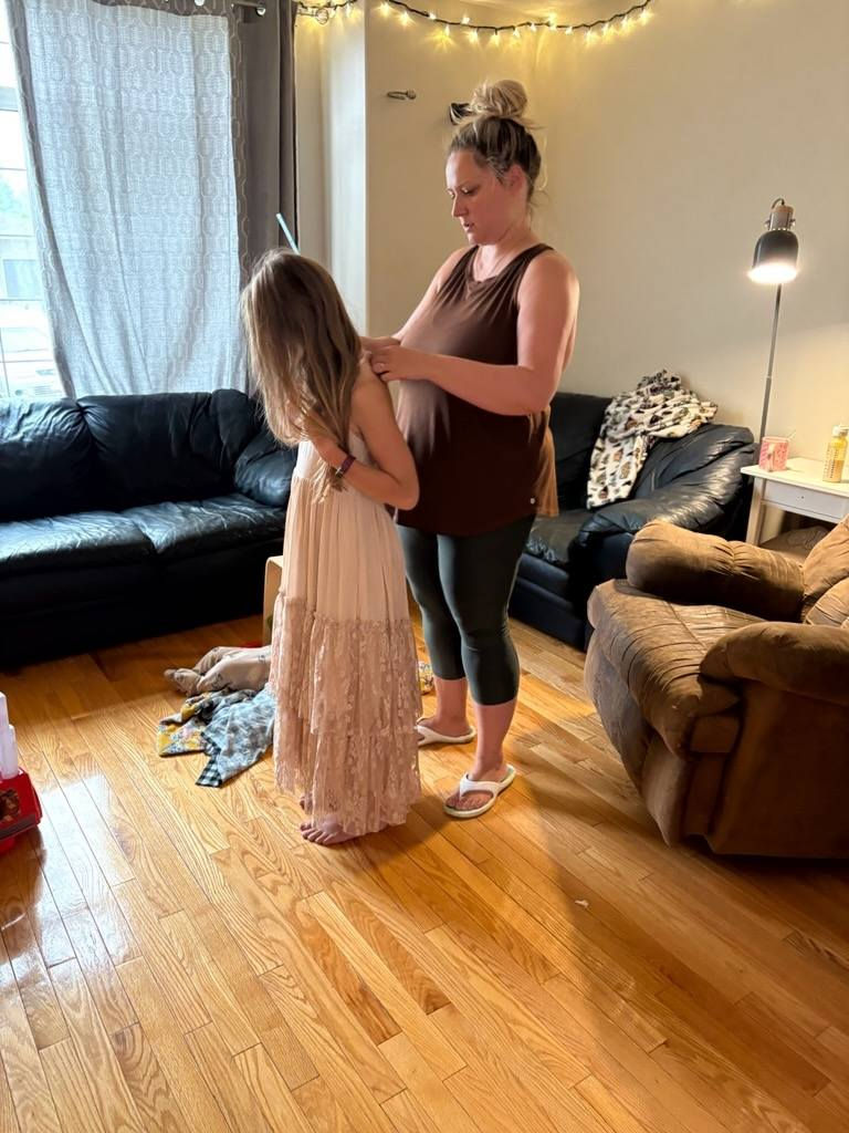 Measuring my niece's dress straps so my mom can sew them shorter.