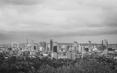 B&W London skyline with London Eye, BT Tower and modern towers under moody clouds.