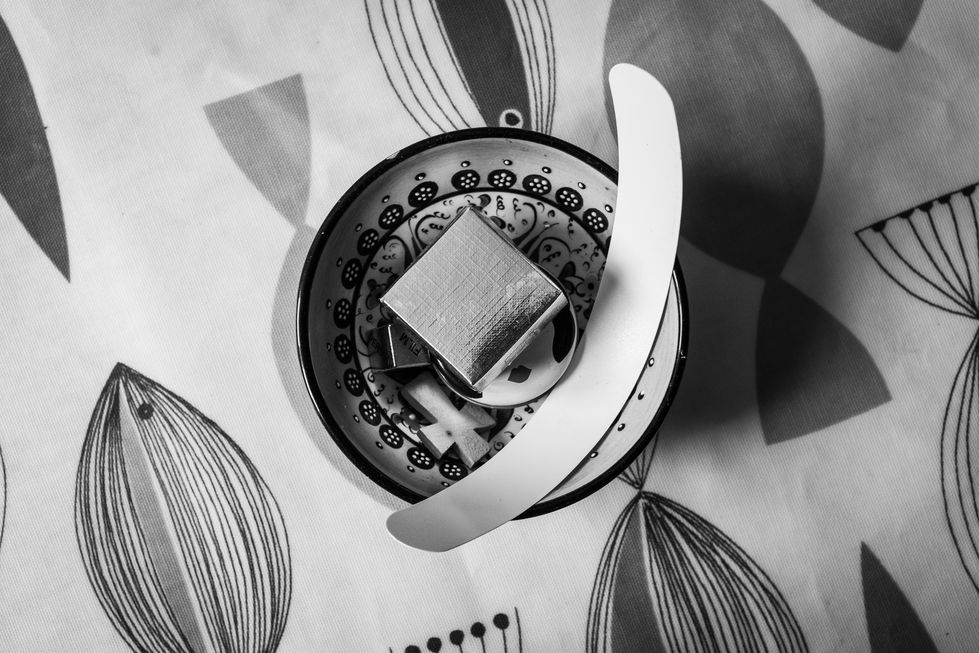 a black and white photo of a bowl and a spoon and a vicar's dog collar