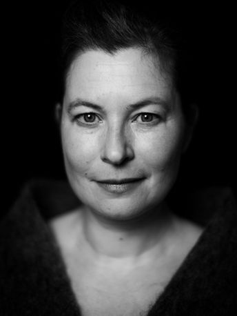 Black and white close-up portrait on dark background.