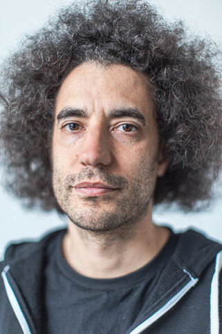 Creative director Justin Audibert in a relaxed natural light portrait, with curly hair adding a sense of texture.