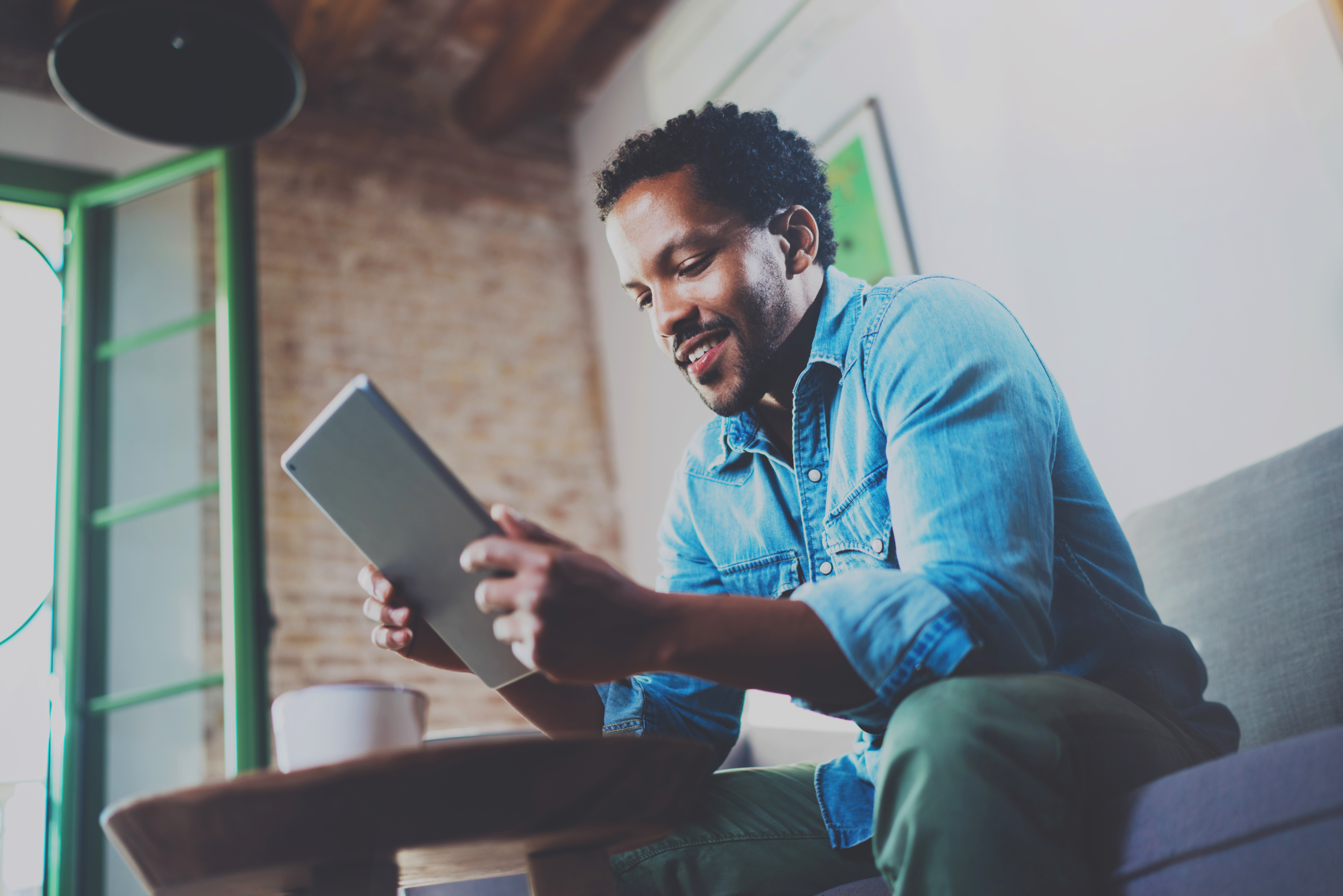 Man reading Only Good News Daily on his tablet