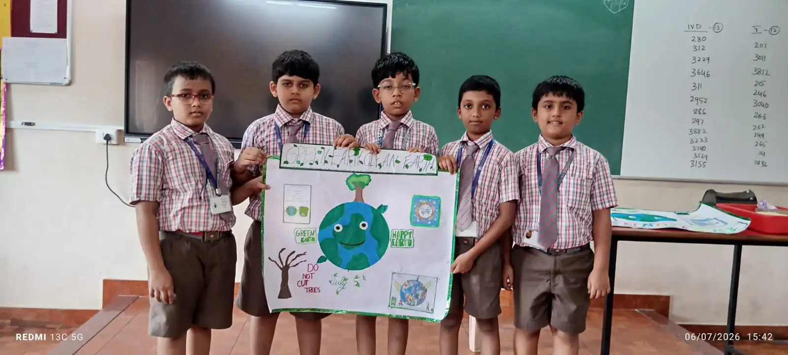 Vidyodaya Public School kids holding up posters and eco-friendly crafts during Vanamahotsav