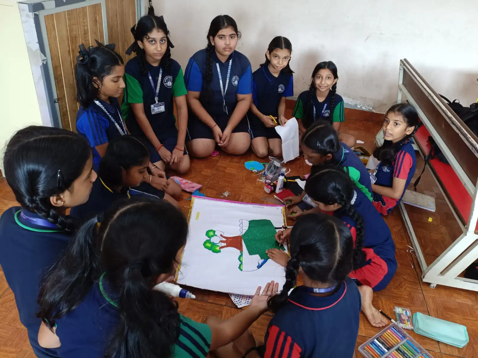 Vidyodaya Public School kids holding up posters and eco-friendly crafts during Vanamahotsav