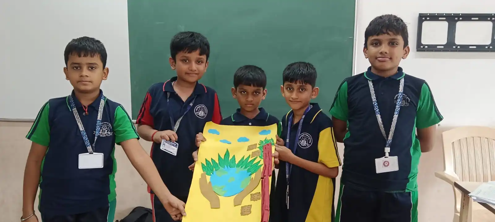 Vidyodaya Public School kids holding up posters and eco-friendly crafts during Vanamahotsav