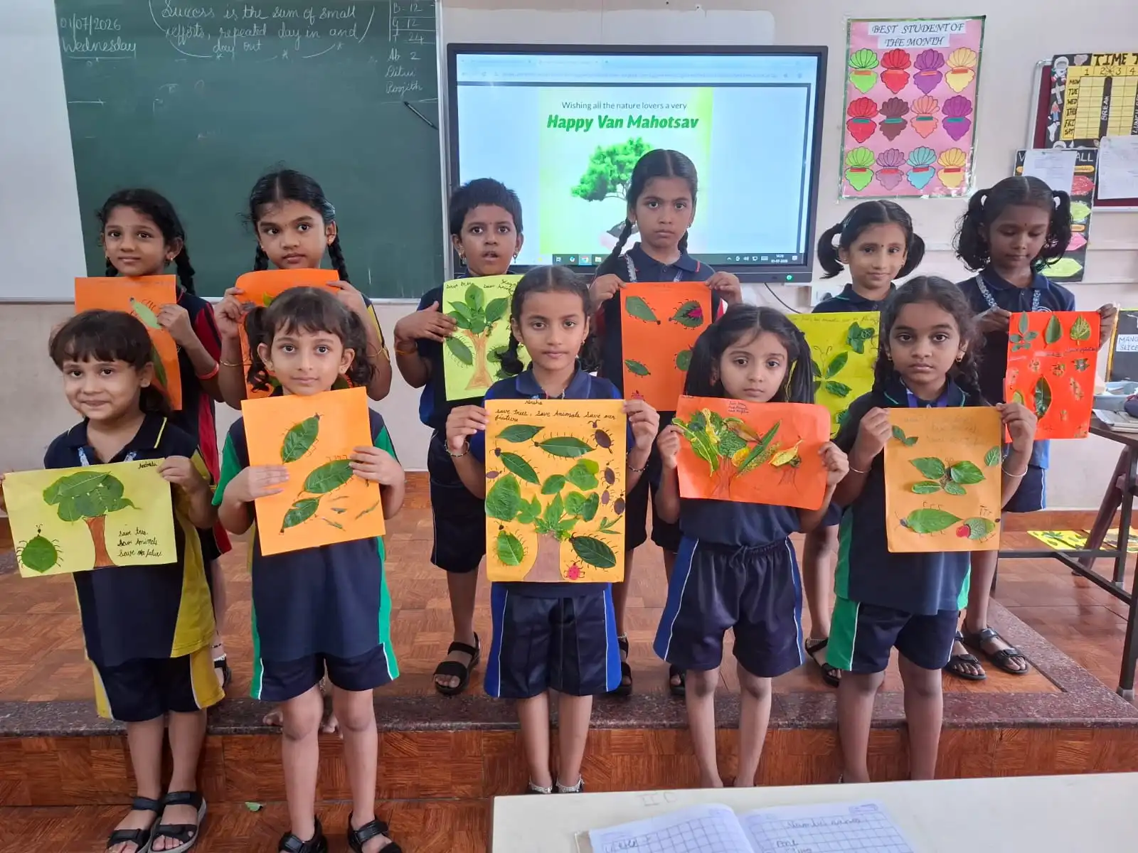 Vidyodaya Public School kids holding up posters and eco-friendly crafts during Vanamahotsav