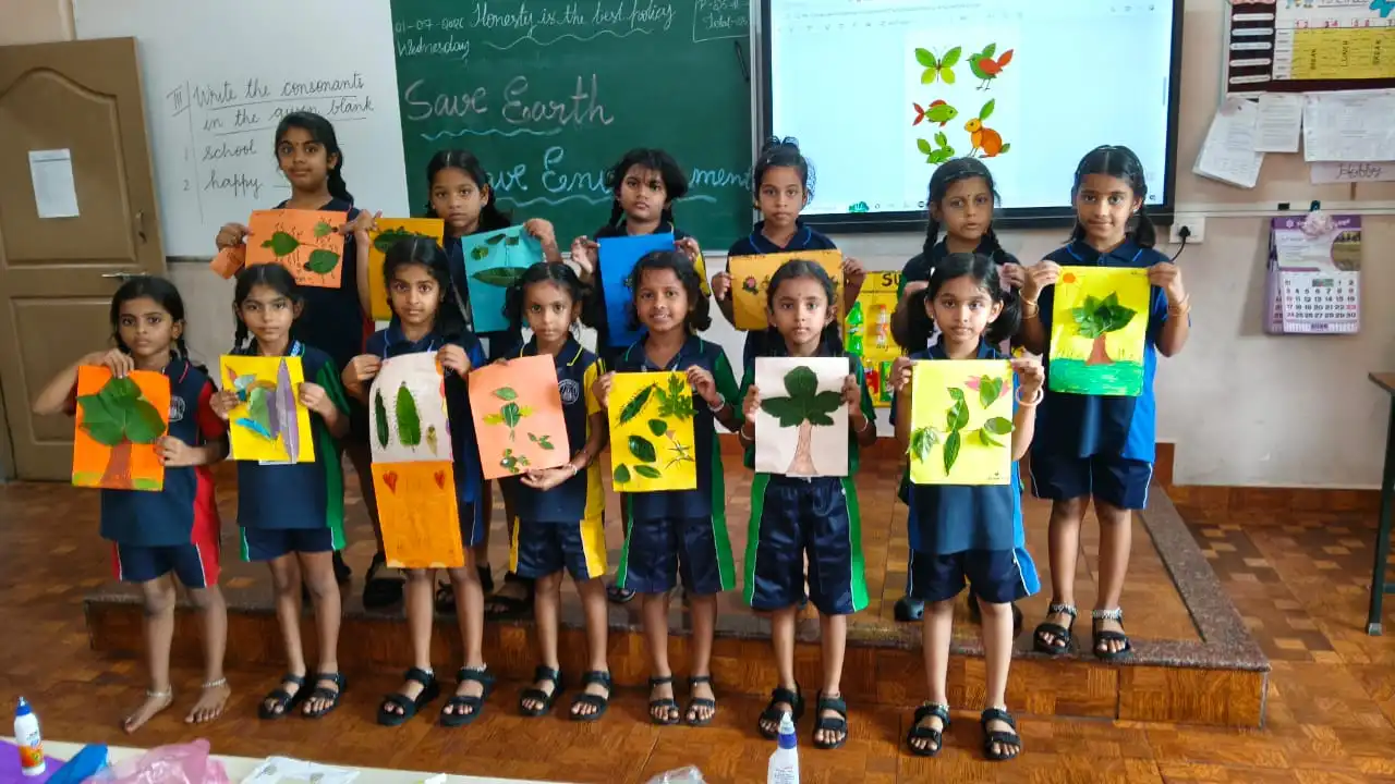 Vidyodaya Public School kids holding up posters and eco-friendly crafts during Vanamahotsav