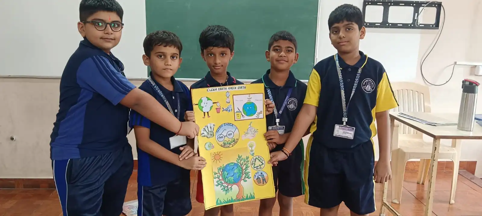 Vidyodaya Public School kids holding up posters and eco-friendly crafts during Vanamahotsav