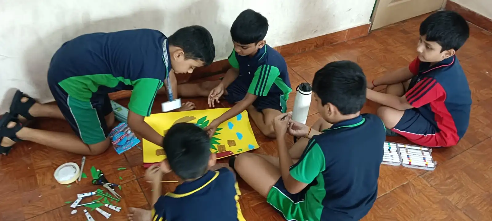 Vidyodaya Public School kids holding up posters and eco-friendly crafts during Vanamahotsav