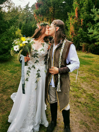 Pora bučiuojasi vestuvių dieną. Jaunikis ir nuotaka; miškas fone. ⌂