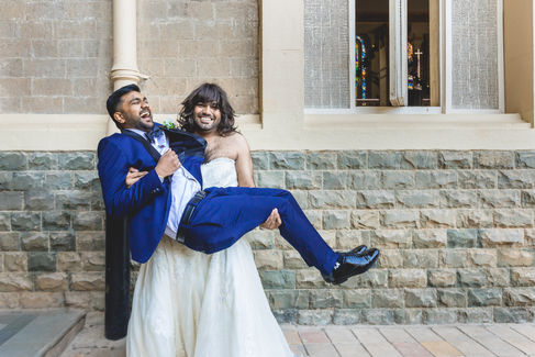Best man dressed in a wedding gown poses with the groom