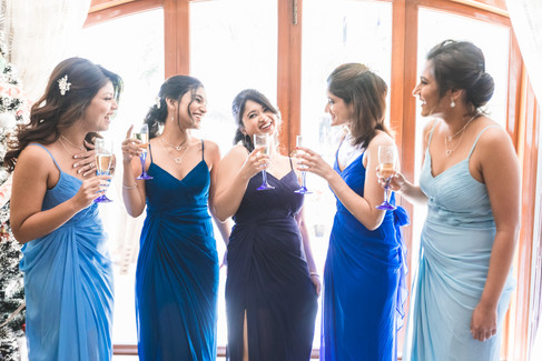 Bridesmaids toasting champagne while getting ready