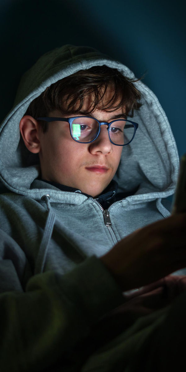 Boy focused on a cellphone screen, representing modern attention overload in a toxin-saturated world.