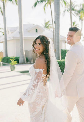 Bride looking back at camera while walking with groom on wedding day in Key West