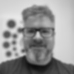 Man wearing glasses smiles at camera About his professional portrait background.