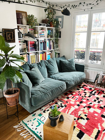 Un tapis berbère Boujaad coloré dans un intérieur parisien bohème avec beaucoup de plantes graphiques
