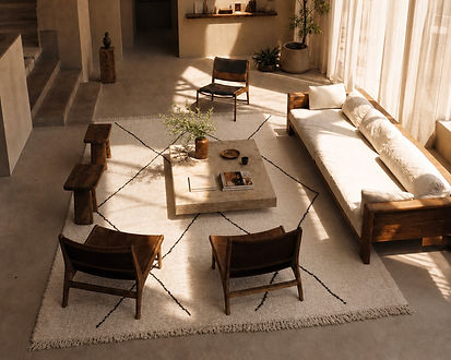Tapis berbère Beni Ouarain  à losanges avec une table en marbre des fauteuils vintage et une déco ethnique