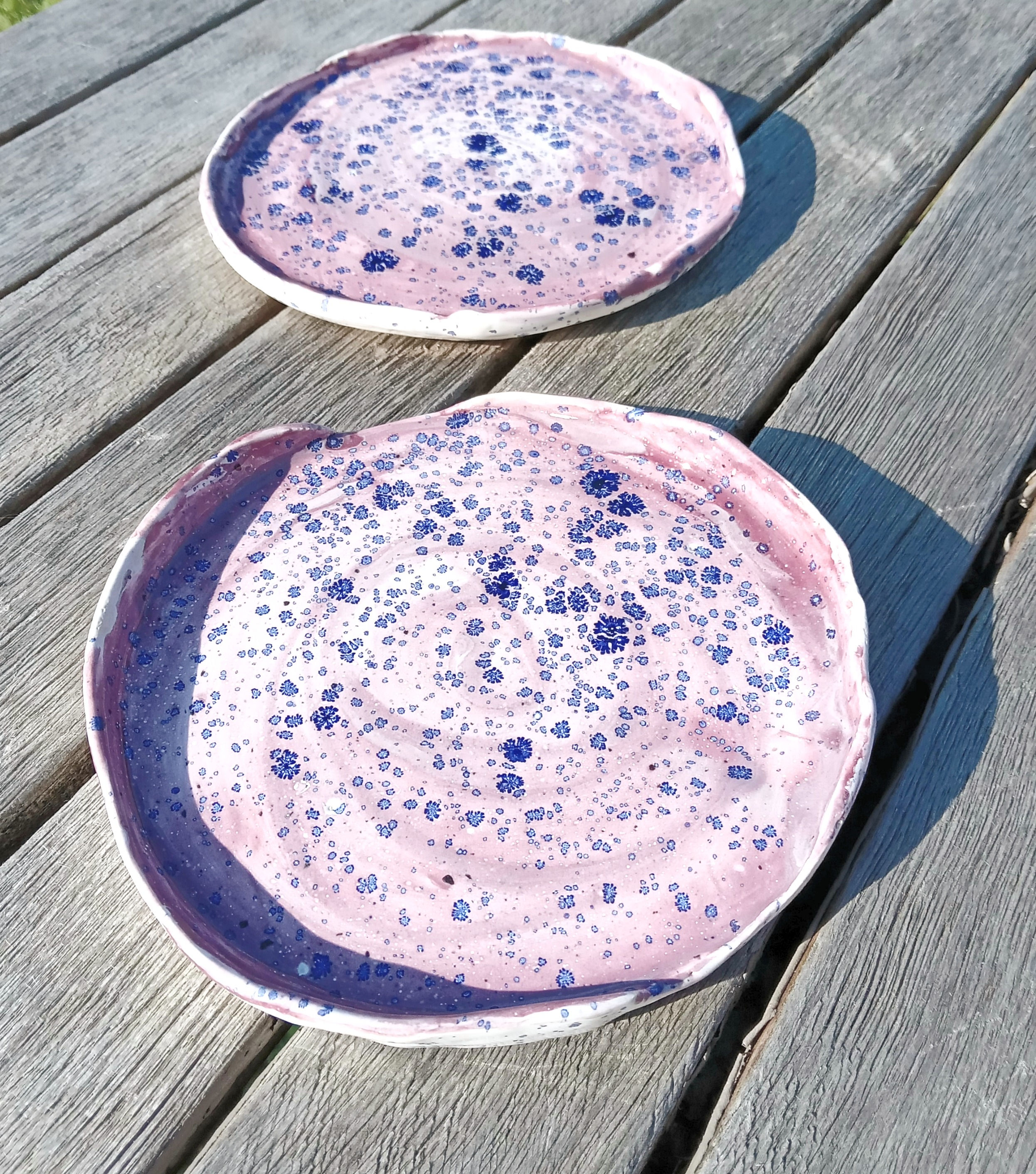 Lot 2 assiettes en faïence émaillée mauve et 'taches' de bleu