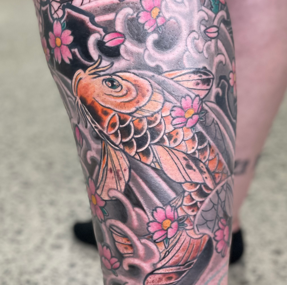 traditional japanese inspired koi fish tattoo with waves and rocks on the lower leg