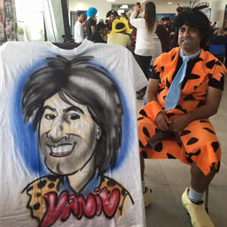 איש מחופש לאדם קדמון עם קריקטורה שלו על חולצה לבנה 