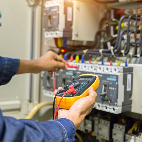 Emergency electrician testing electrical switchboard with multimeter | 24-7 Electrical Assistance by EE Electrics