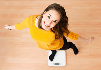 Portrait of young brunette beauty using household scale._edited.jpg