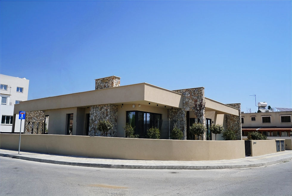 Street view of Villa Gaia in Larnaka, with a flat roof, stone-clad walls and deep shaded windows.