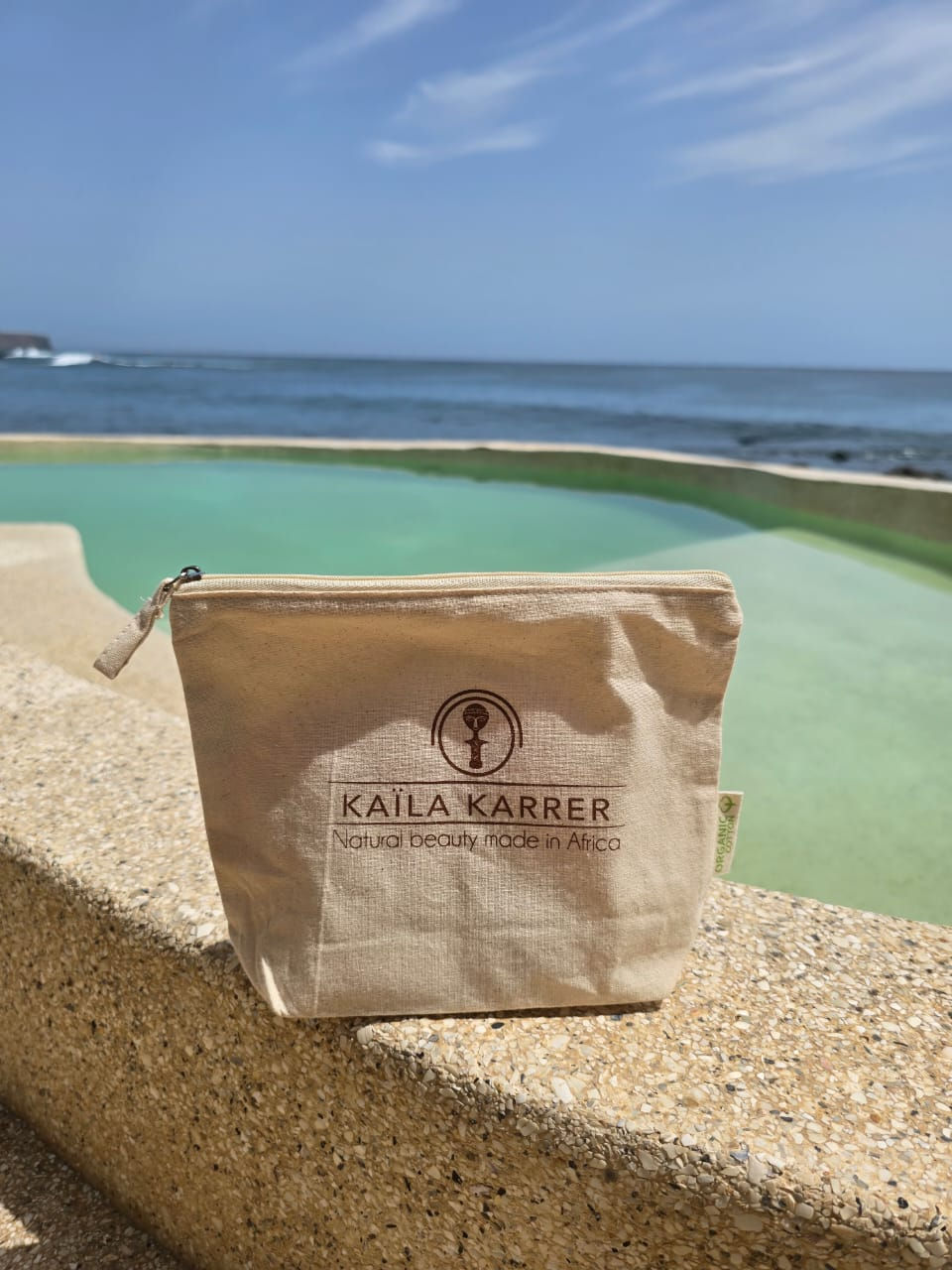 une trousse de toilette en coton au bord d'une piscine vue sur mer