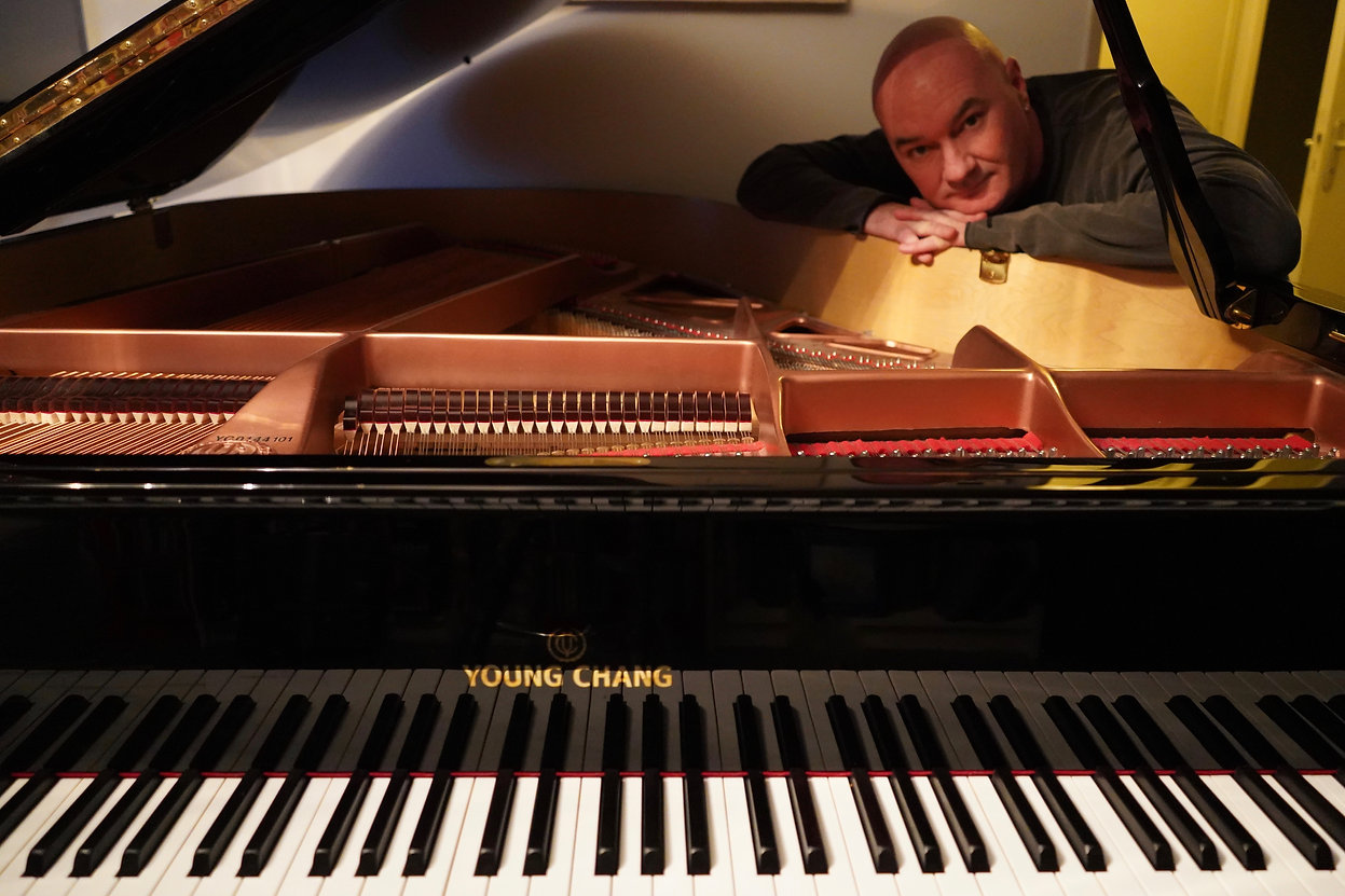 Seamus Kearney at home with his baby grand piano