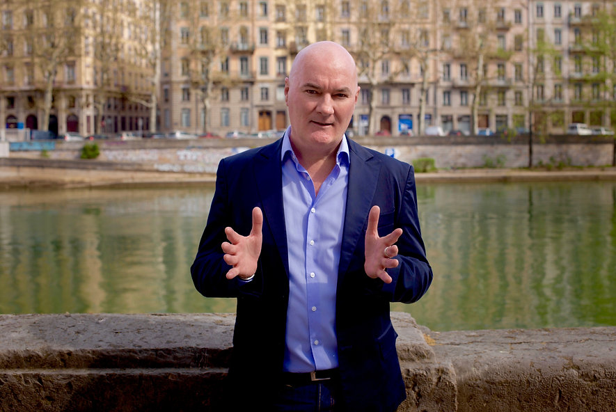 Seamus Kearney of Seamus Kearney Media, piece to camera for a TV report. Seamus Kearney, Seamus Kearney Media, TV & Radio Journalist, France & Europe Correspondent, Freelance & Independent, Media Relations Consultant, Media Trainer, Moderator of Conferences & Debates, Based in Lyon, France