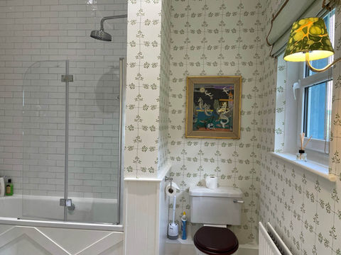 Luxurious en-suite bathroom featuring bath with shower over. 