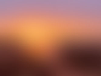 Sunset over a rocky shore with vivid orange and purple hues reflecting on the water, header image related to the blog post "A Meandering Trip Along Spain’s Unsung Orange Blossom Coast"