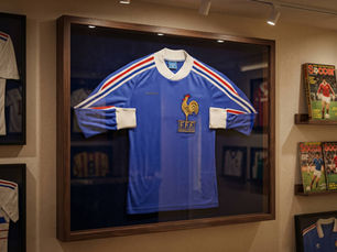 Framed blue French soccer jersey with FFF logo and tricolor stripes. Header image related to the blog post "The Most Controversial World Cup Jerseys"