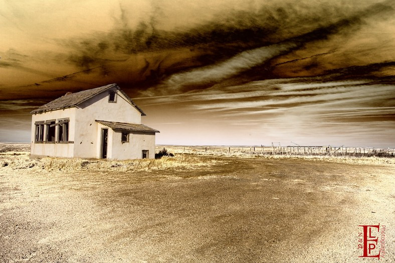 abandoned farm house under dusty sky