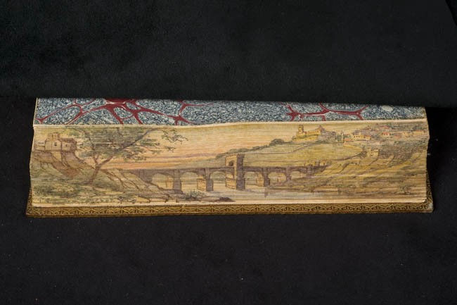 detailed pastoral painting on edge of book