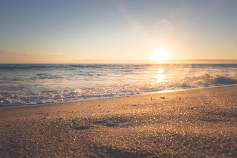 The sun rising over a deserted beach