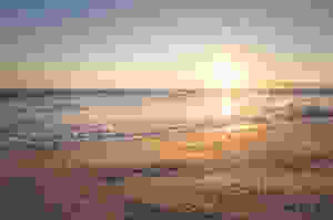 The sun rising over a deserted beach