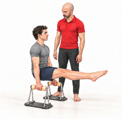 Client performing an L-sit exercise on Pilates push-up handles while his instructor observes.