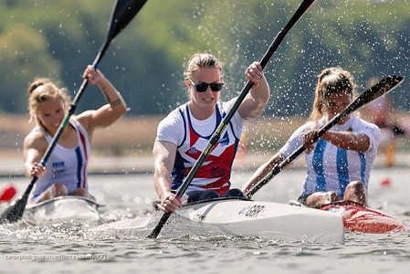 Emma Russell leads in her kayak, with France and Argentina close behind.