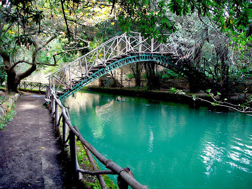 A lush, green oasis at Seven Springs (Epta Piges) in Rhodes, featuring natural water springs, a serene lake, and tall plane trees, located just a short drive from Aura Luxury Villas in Afantou.