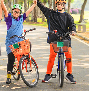 three children riding bikes in a park