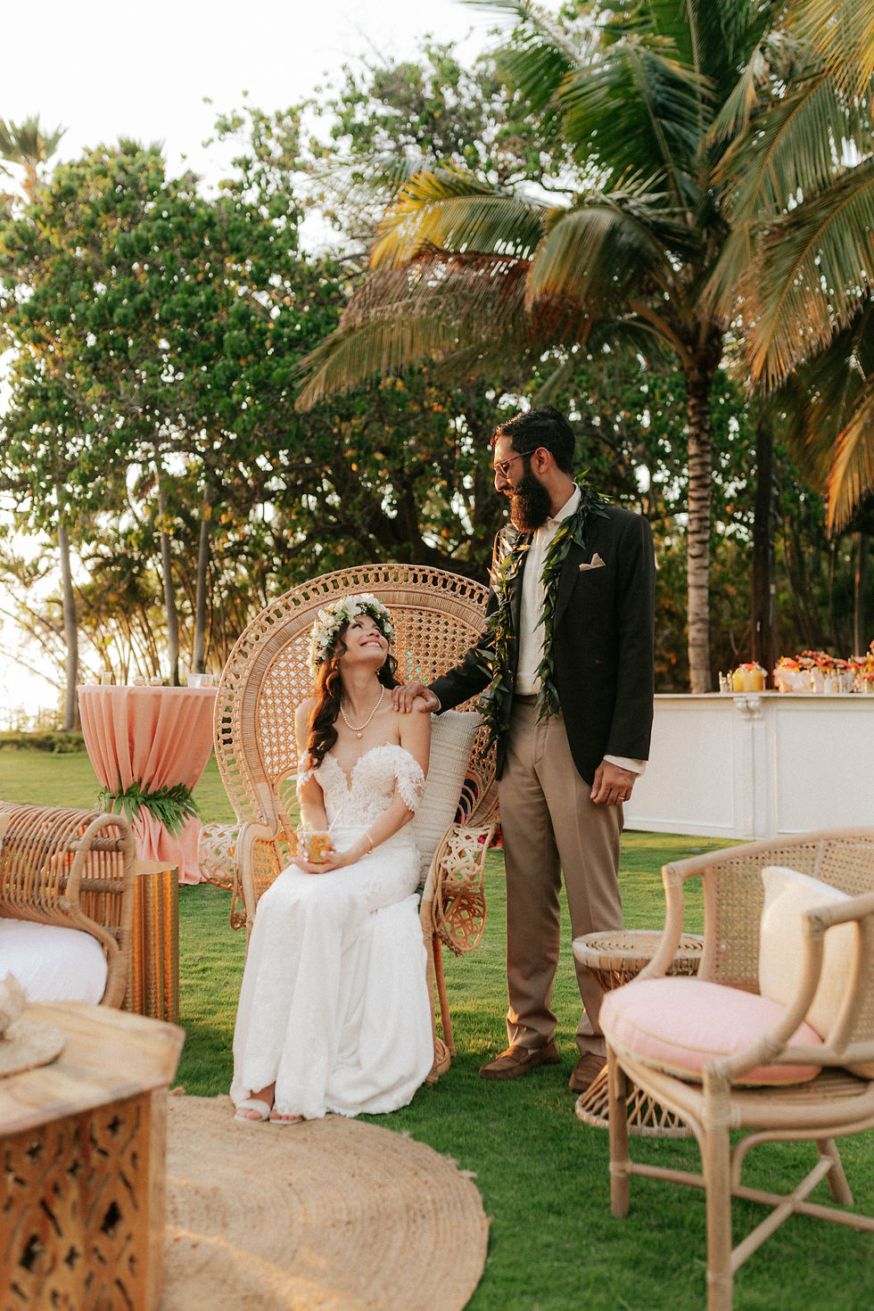 Outdoor lounge area set up with cozy seating options and warm lighting, overlooking the ocean at sunset, providing a perfect spot for guests to relax and take photos.