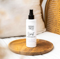 A sleek amber glass spray bottle of Uplift Room Mist by Hudson and Kingsley The Label, infused with revitalizing essential oils-designed to refresh your space with a clean, energizing aroma.